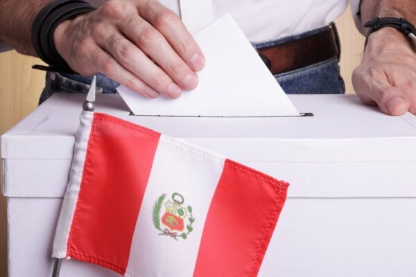 Es una persona ingresando su voto a la urna.